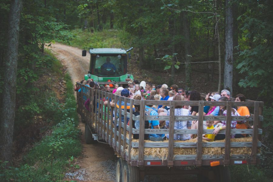 Tractor pulling a hayride wagon through the woods