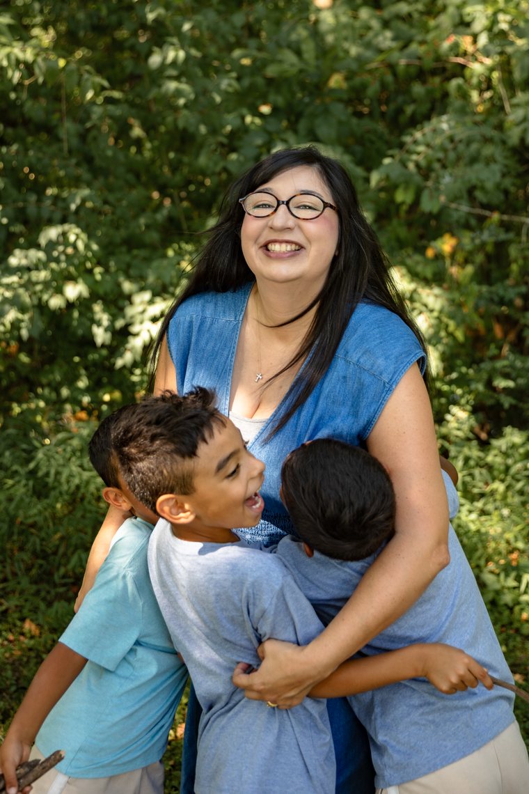 Jennifer laughing as her kids hug her